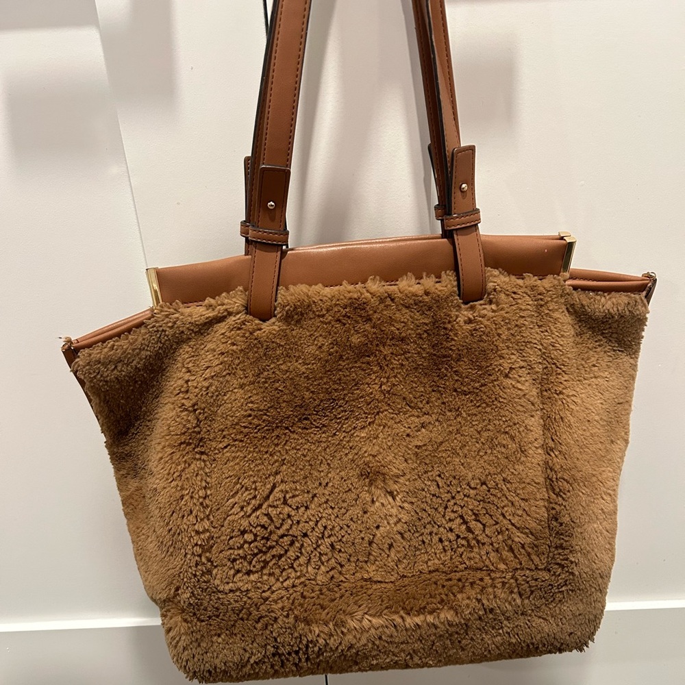 Furry. Very clean. No rips except on inside side pocket. Closes magnetically